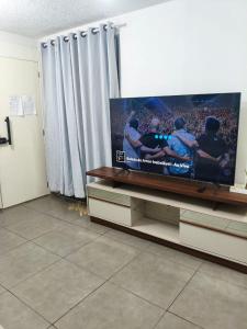 a large flat screen tv sitting on a entertainment center at Aconchegante apto na Z Oeste in Sao Paulo