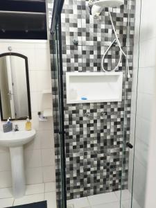 a bathroom with a shower with a sink and a mirror at Aconchegante apto na Z Oeste in Sao Paulo +40 photos
