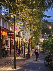 a man walking down a street at night at HOME STYLE at Platinum Suites KLCC Twin Towers in Kuala Lumpur