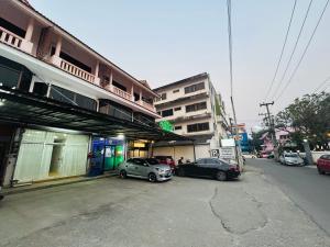 twee auto's geparkeerd op een parkeerplaats naast een gebouw bij Sun sun house in Chiang Mai