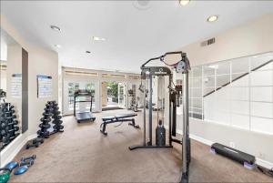 einen Fitnessraum mit mehreren Laufbändern und Gewichten in einem Zimmer in der Unterkunft Ritz Pointe Paradise! in Dana Point