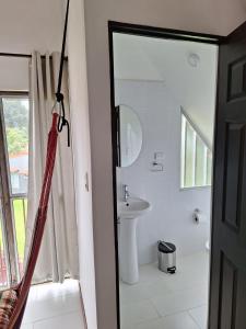 a bathroom with a shower curtain and a sink at Casa Luna Poás Costarica in Sabana Redonda