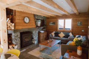 a living room with a fireplace in a log cabin at Chalet Dranse skiVTT - Mountain Voyages chalet in Saint-Jean-d'Aulps
