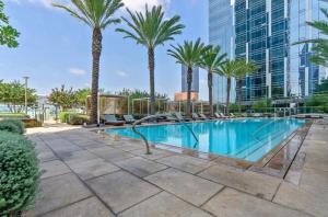 une piscine avec des palmiers et un bâtiment dans l'établissement Modern Brand New 1BD 1BTH DTLA, à Los Angeles