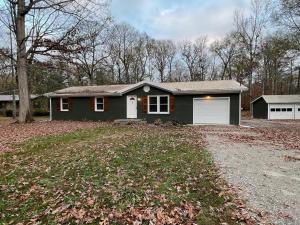 una casa verde con un garage in un cortile di Remodeled Cottage With Sunroom a Manchester