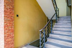 a staircase in a building with a yellow wall at RedDoorz at Kutisari 2 Surabaya in Surabaya +30 photos