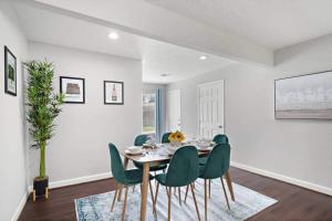 a dining room with a table and green chairs at Htown Escape Nr Med Center, Galleria, Nrg Games in Houston