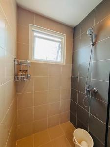 a bathroom with a shower with a toilet and a window at 11 Poolside Balcony Bliss in Iloilo City +20 photos