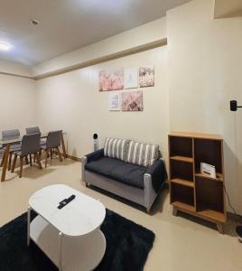 a living room with a couch and a table at 11 Poolside Balcony Bliss in Iloilo City