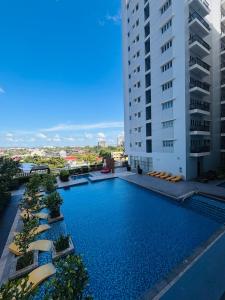 a large swimming pool next to a tall building at 11 Poolside Balcony Bliss in Iloilo City