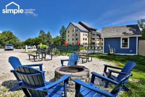 a group of blue chairs around a fire pit at The Snowshed Steps at Mt Green - Walk-to-Lifts Ski Condo with Pools, AC, Fireplace & Shuttle! in Killington
