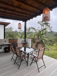 a patio with a table and chairs and a stove at Wasi loma casa campestre in Pedro Vicente Maldonado