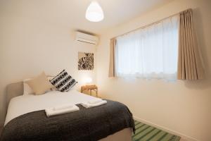 Un dormitorio con una cama con dos toallas encima. en 静和 旅タイム千本南, en Osaka