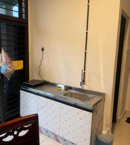 a kitchen counter with a sink in a room at Taman Sri Utama Gurun 