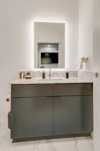 un baño con lavabo y espejo en Luxury 2-bd, 2-bth Downtown Riverfront, Park Free, en Nashville