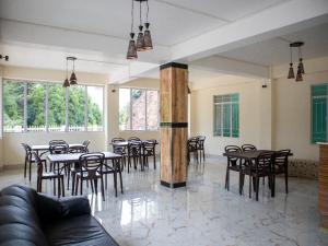 a dining room with tables and chairs and windows at esS PHLYNDA Inn in Lāitlyngkot