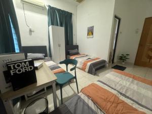 a room with three beds and a table with a sign at Taman Sri Utama Gurun 