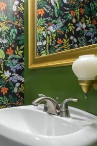 baño con lavabo, espejo y una foto en Hot Cocoa Bar 4 Season Porch Wwood Stove, en Pocono Country Place