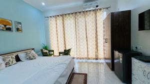 a bedroom with a bed and a large window at Next Little Door in Dehradun