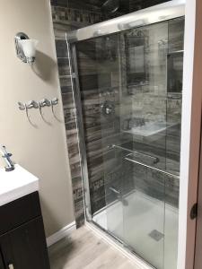 a shower with a glass door in a bathroom at Beautiful Four Bedroom Lagoon City Waterfront Home in Brechin