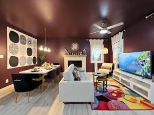 ein Wohnzimmer mit einer Couch, einem Fernseher und einem Tisch in der Unterkunft Regal Ranch Retreat in Lawrenceville