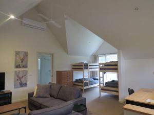a living room with a couch and bunk beds at Blue Bird Cottage in Merrijig
