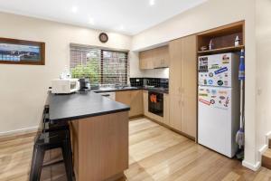a kitchen with a counter and a refrigerator at Sawmill Retreat in Merrijig