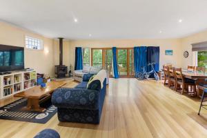 a living room with a couch and a table at Sawmill Retreat in Merrijig