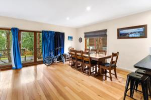 a dining room with a table and chairs and a bike at Sawmill Retreat in Merrijig +4 photos