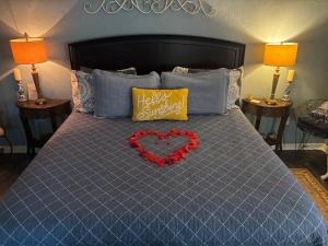 un letto blu con un cuscino a forma di cuore e un cuscino giallo con un San Valentino di Cottages At Willow Pond a Guthrie
