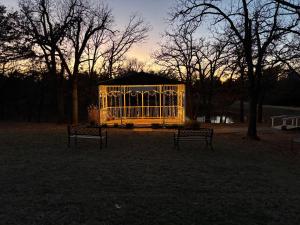 due panchine sedute in un gazebo in un parco di Cottages At Willow Pond a Guthrie