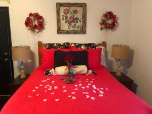 un cane sdraiato su un letto rosso con un vaso di fiori di Cottages At Willow Pond a Guthrie