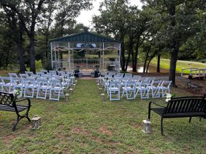 un gruppo di sedie bianche e un gazebo di Cottages At Willow Pond a Guthrie