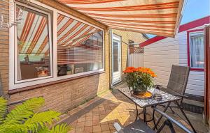 a patio with a table with a vase of flowers on it at 2 Bedroom Beach Front Home In Egmond Aan Zee in Egmond aan Zee