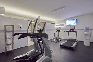 a gym with treadmills and ellipticals in a room at Sunday Hotel Köln Hürth in Hürth
