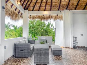 un patio al aire libre con muebles de mimbre y una mesa en Casa Solaje - Modern Costal house 5 min from Zica, en Puerto Escondido