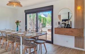 a dining room with a table and chairs and a mirror at Magnifique Maison Avec Spa in Hillion