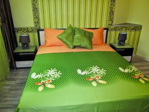 - un lit avec une couverture verte et des papillons dans l'établissement Apartments Vasil Levski, à Plovdiv