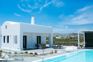 a white villa with a swimming pool and a building at Zafira Residence in Karterados