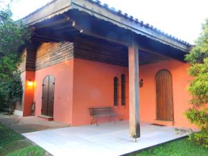 a small orange house with a bench in front of it at Casa do sol in Monte Verde