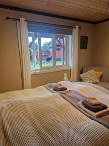 克里斯蒂安桑Villa Svale, privat og fredelig的一张带两条毛巾的床和窗户