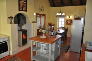 a kitchen and dining room with a fireplace and a table at Bredon Cottage in Hogsback