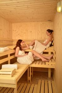 two women are sitting in a sauna at Enjoy Inn in Plzeň