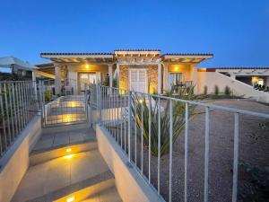 罗萨岛Lovely Beach Suite的前面有栅栏和灯的房子