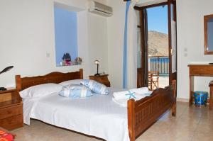 a bedroom with a bed with white sheets and blue pillows at Kamares Studios in Symi