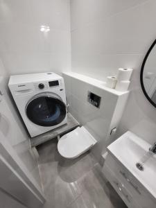 a bathroom with a toilet and a washing machine at Apartament Centrum in Gdynia