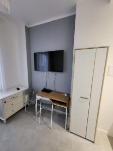a room with a desk and a tv on a wall at Apartament Centrum in Gdynia