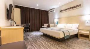 ein Hotelzimmer mit Bett und Schreibtisch in der Unterkunft City Comfort Inn Nanning Wuming Xiangshan Avenue in Wuming