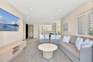 una sala de estar con un sofá y una mesa en Pacific Blue Unit 175 Dual Swim Up, en Salamander Bay