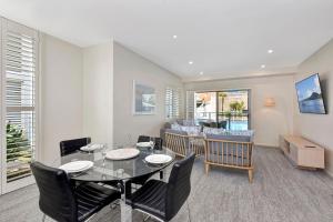 Un comedor y una sala de estar con mesa y sillas. en Pacific Blue Unit 175 Dual Swim Up, en Salamander Bay